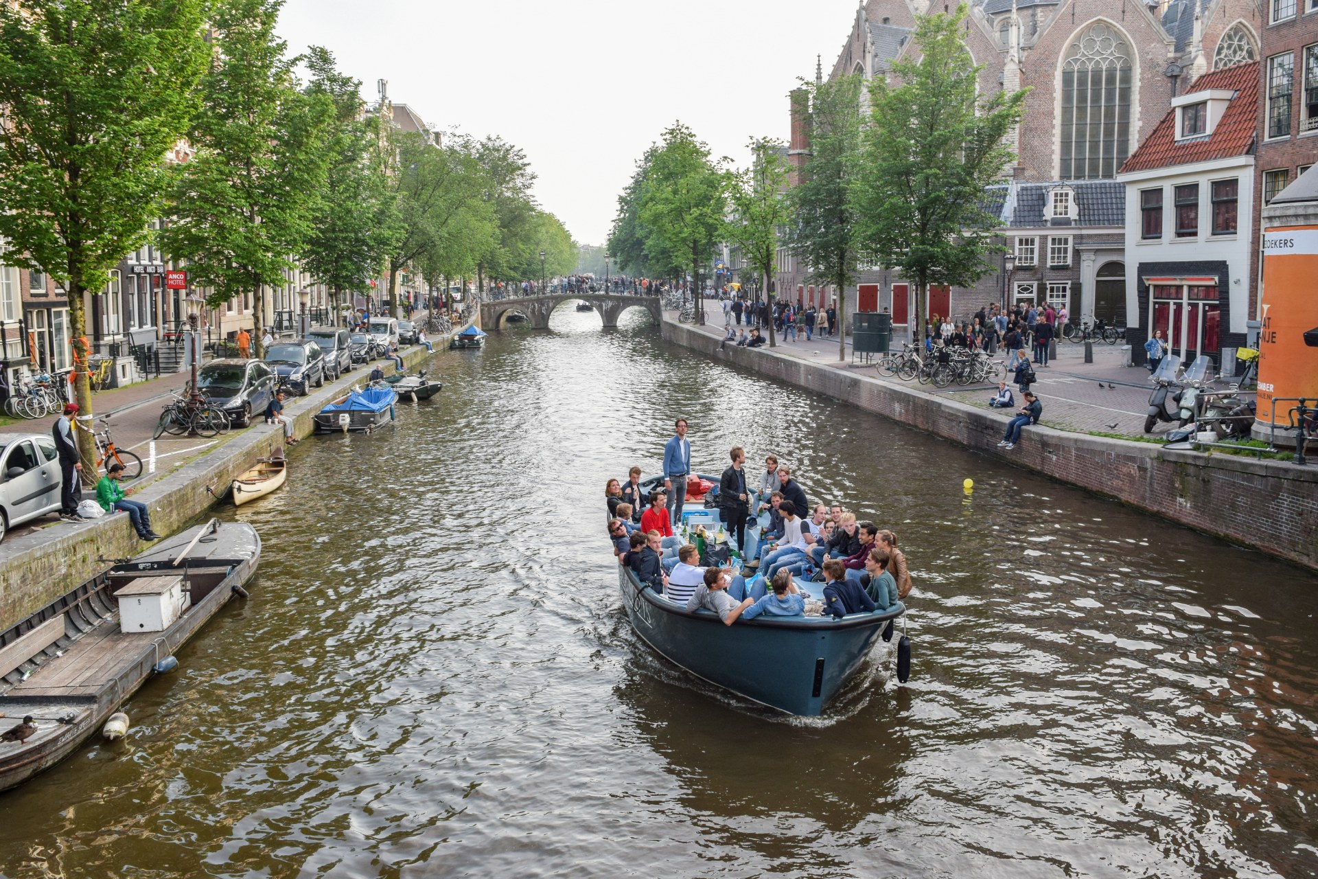 Mladí lidé na lodi na amsterodamském kanálu